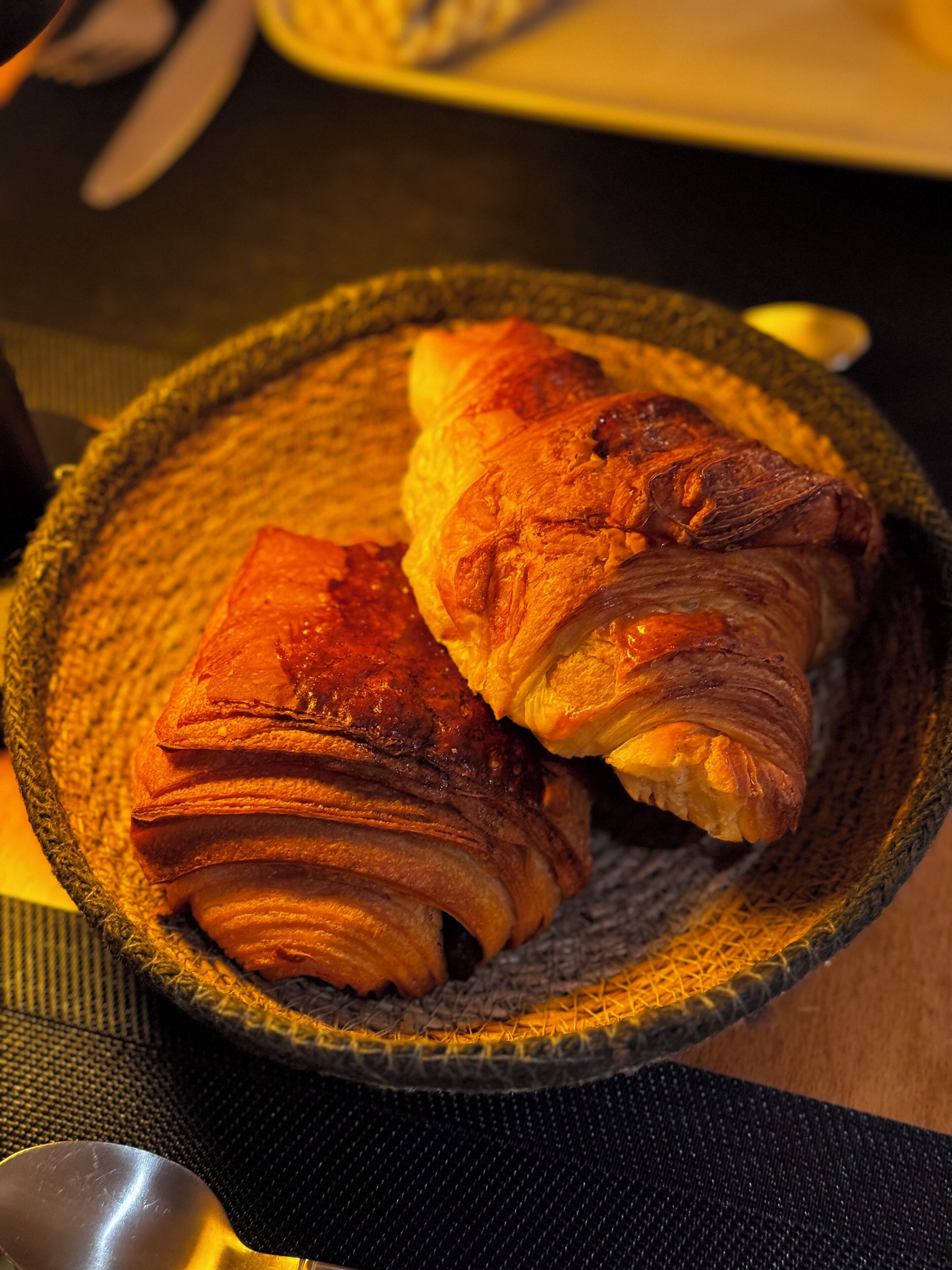 Un bol de croissants sobre un plat amb textura.