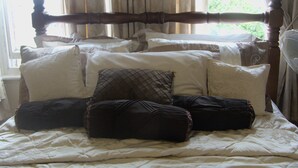 A bed with a wooden headboard, multiple pillows, and a white bedspread. - Ms McCreadys Guest House (Doncaster)