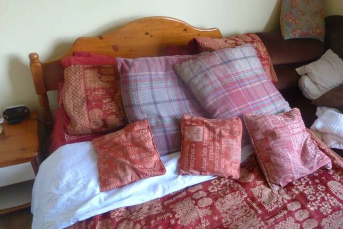 Cama com várias almofadas e colcha estampada.