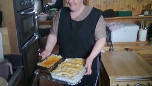 A kitchen with a stove, oven, and a person holding a tray of food. - Ms McCreadys Guest House (Doncaster)
