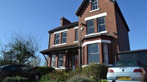 A two-story brick house with a bay window and a garage. - Ms McCreadys Guest House (Doncaster)