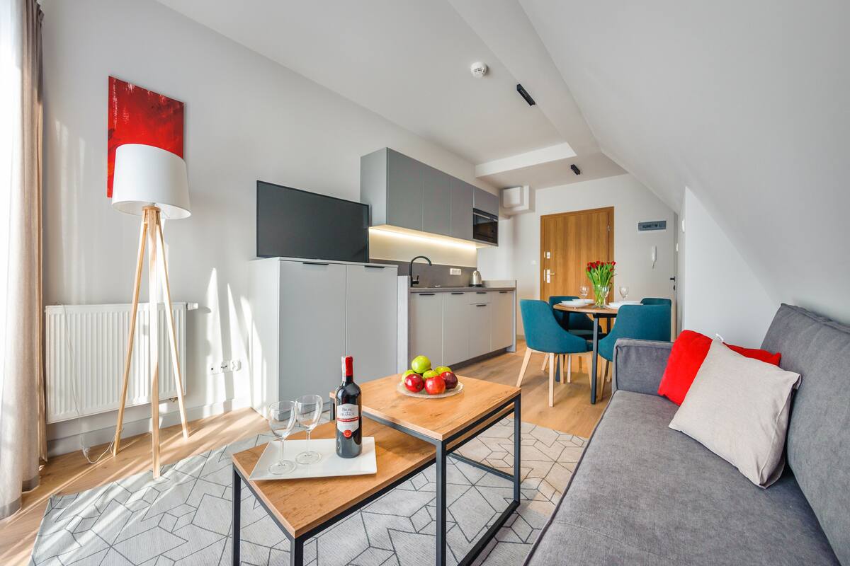 A modern apartment with a dining area, kitchen, and living room.