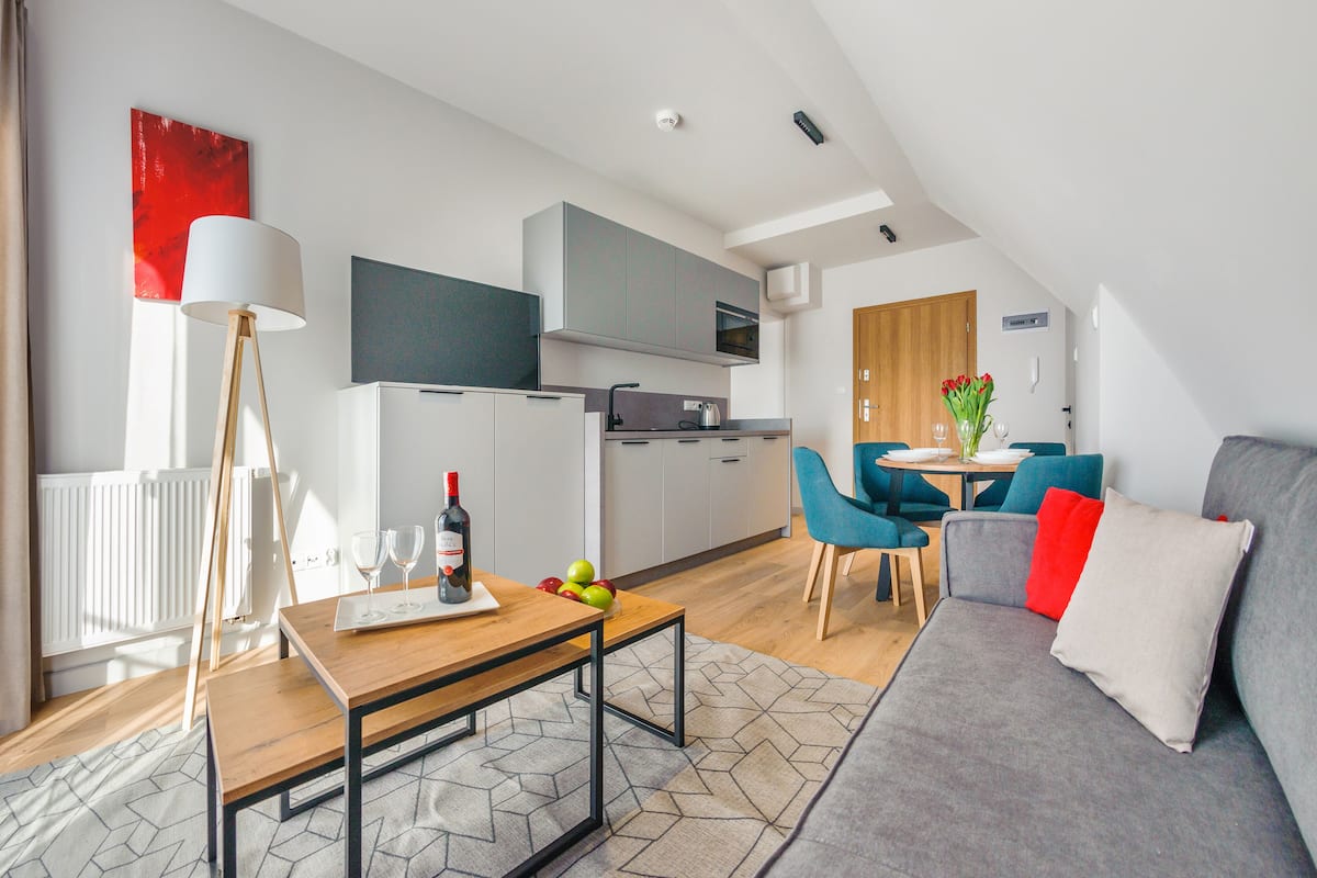 A modern apartment with a dining area, kitchen, and living room.
