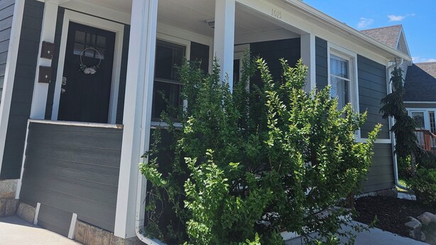 A two-story house with a covered front porch and a small tree in the front yard. - Downtown 1 Bedroom Charmer - Walk, Bike, Visit, Enjoy!! (Rapid City)