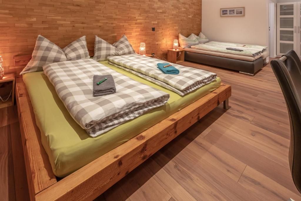 Une pièce avec deux lits en bois, un mur en briques et un plancher en bois.