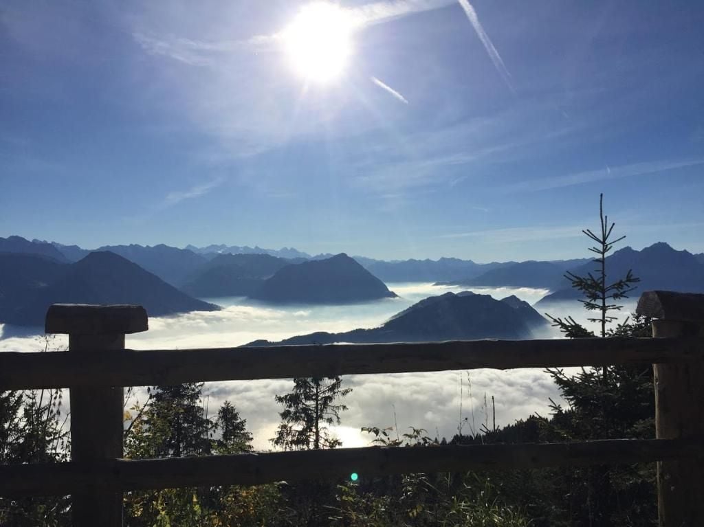 Un paisaje montañoso con una valla de madera al frente.