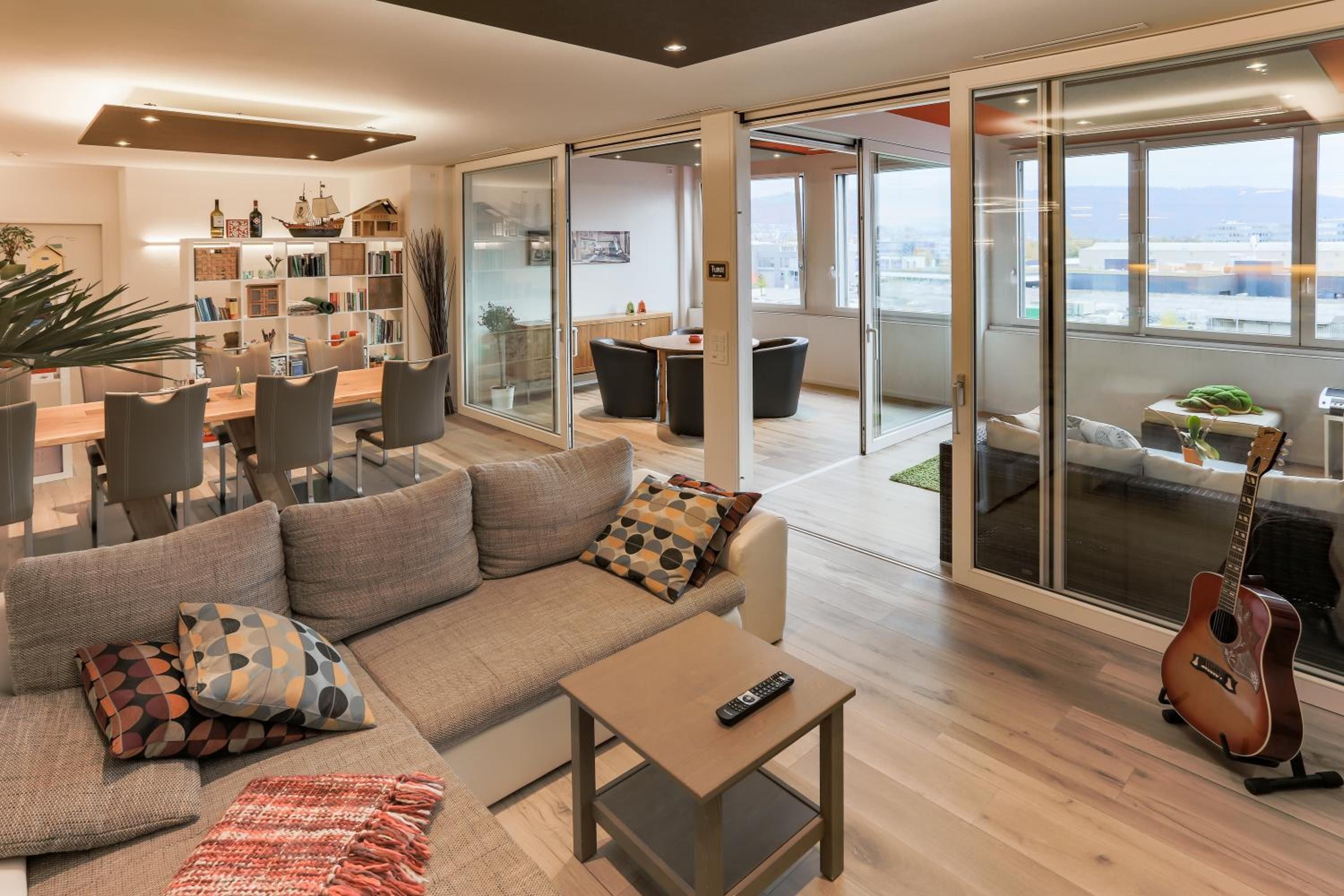 A modern living room with a sofa, coffee table, and a guitar.