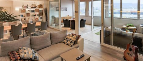 A modern living room with a sofa, coffee table, and a guitar.