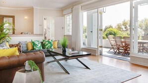 Ein modernes Wohnzimmer mit Sofa, Couchtisch und Blick auf eine Terrasse.