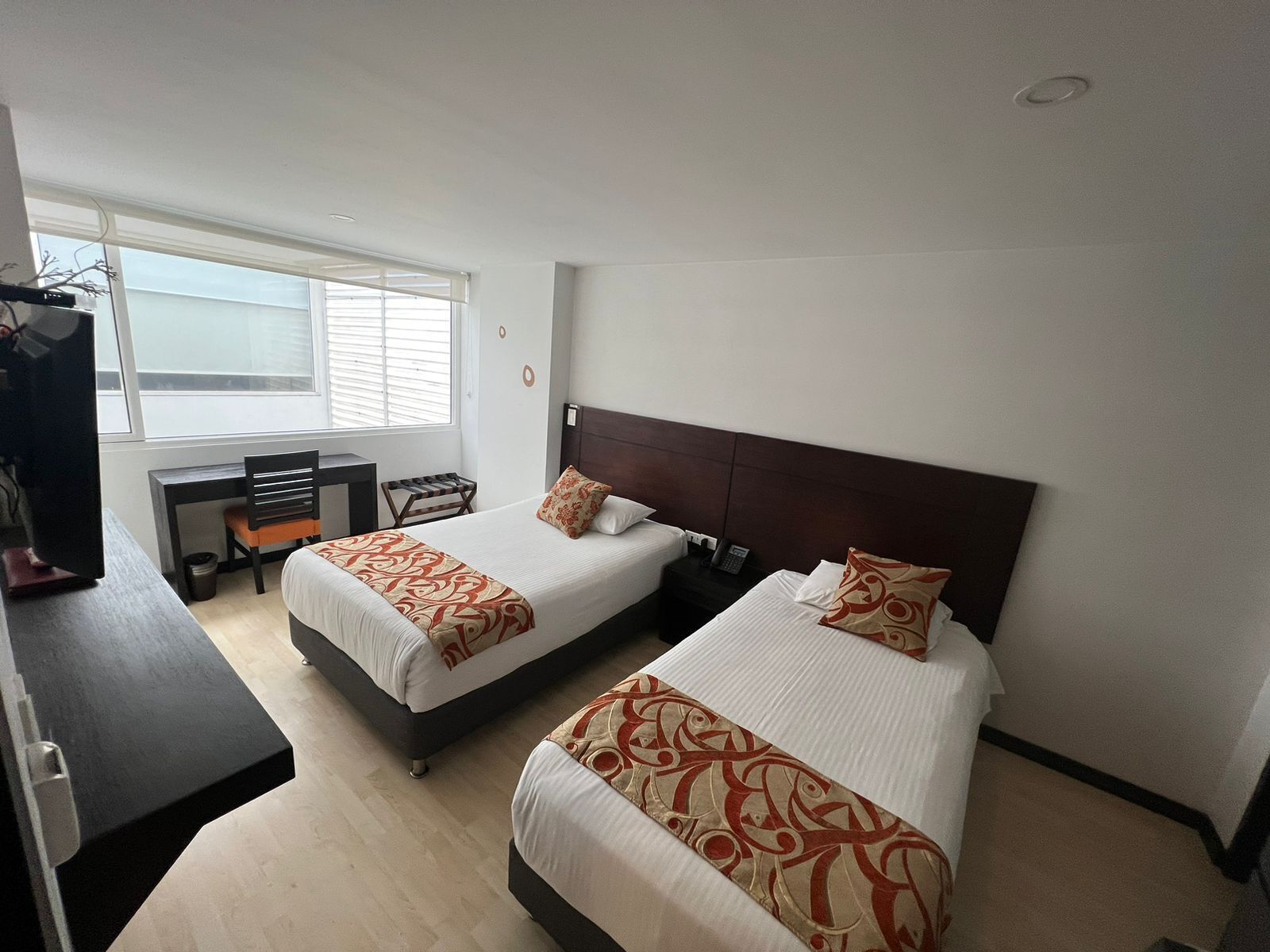 Una habitación de hotel con dos camas, un escritorio y una silla.