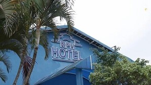 The exterior of RPH Hotel with a blue facade, a visible entrance, and palm trees in the foreground. - Tis Hotel 153 (Prata)
