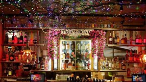 A bar with a variety of liquor bottles, a sign reading 'MART ROAD,' and a decorative archway. - Cherry Bar Rooms (London)