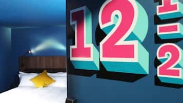 A bedroom with a bed, a nightstand, and a wall with large numbers.