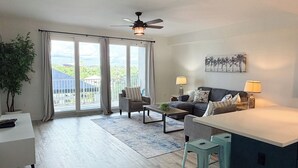 Ett modernt vardagsrum med en soffa, ett soffbord och en matplats.