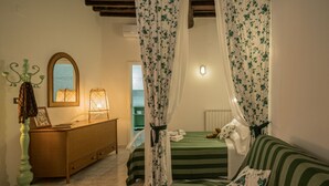 Una camera da letto con un letto, una cassettiera, uno specchio e un comodino.