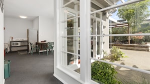 Een lichte kamer met een groot raam, een kitchenette en uitzicht.