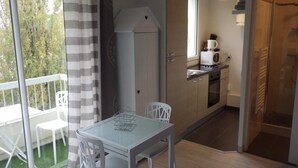 A compact kitchen with a microwave, stove, and cabinets. - STUDIO DOWNTOWN LA BAULE (La Baule)