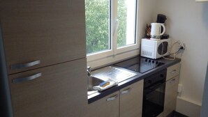 A modern kitchen with a built-in microwave, oven, and sink. - STUDIO DOWNTOWN LA BAULE (La Baule)