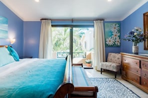 Une chambre à coucher avec un lit, une chaise, une commode et une vue sur l’extérieur.