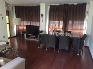 A modern living room with a flat-screen TV, wicker furniture, and a glass coffee table. - Unbeatable by state and situation, 50 meters from the new beach and downtown (Altea)