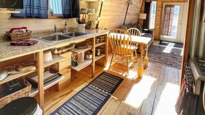 Une cuisine de taille réduite avec une table en bois, des chaises et un évier.
