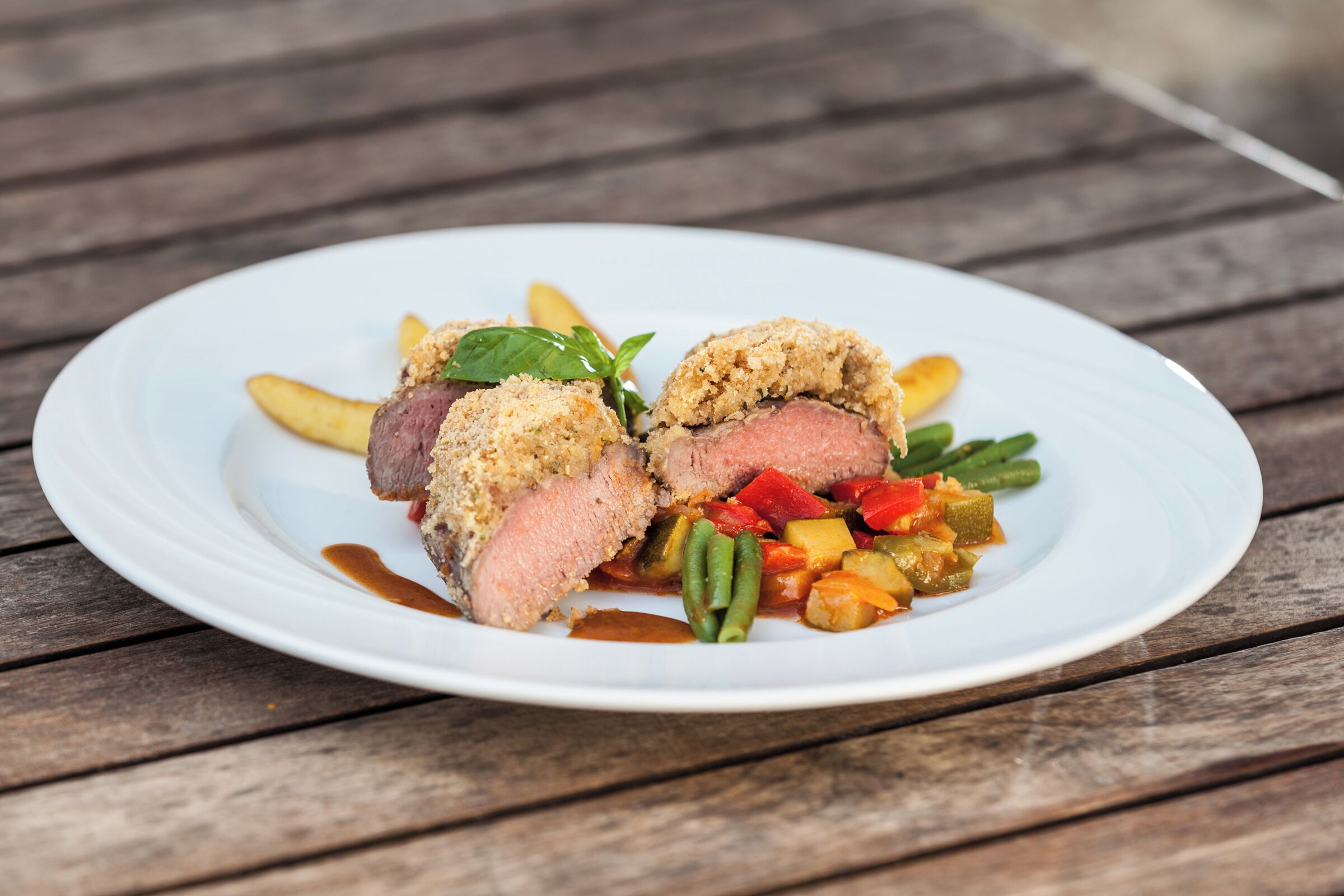 A plate of food with a white plate on a wooden table.