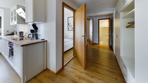A modern kitchen with white cabinets, a coffee machine, and a wooden countertop. - Fantastic central Zugspitze view with parking lot  (Garmisch-Partenkirchen)