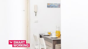 Un comedor moderno con una mesa para dos personas, una pizarra y un cuadro en la pared.