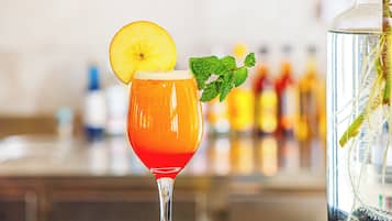 A cocktail with a slice of fruit and a mint garnish.