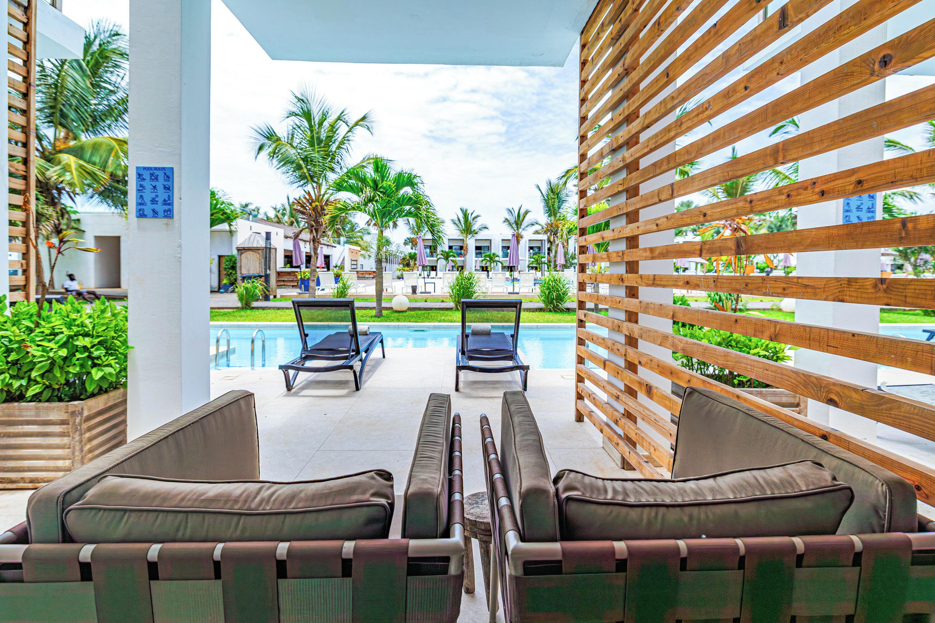 A poolside area with lounge chairs and a wooden pergola.