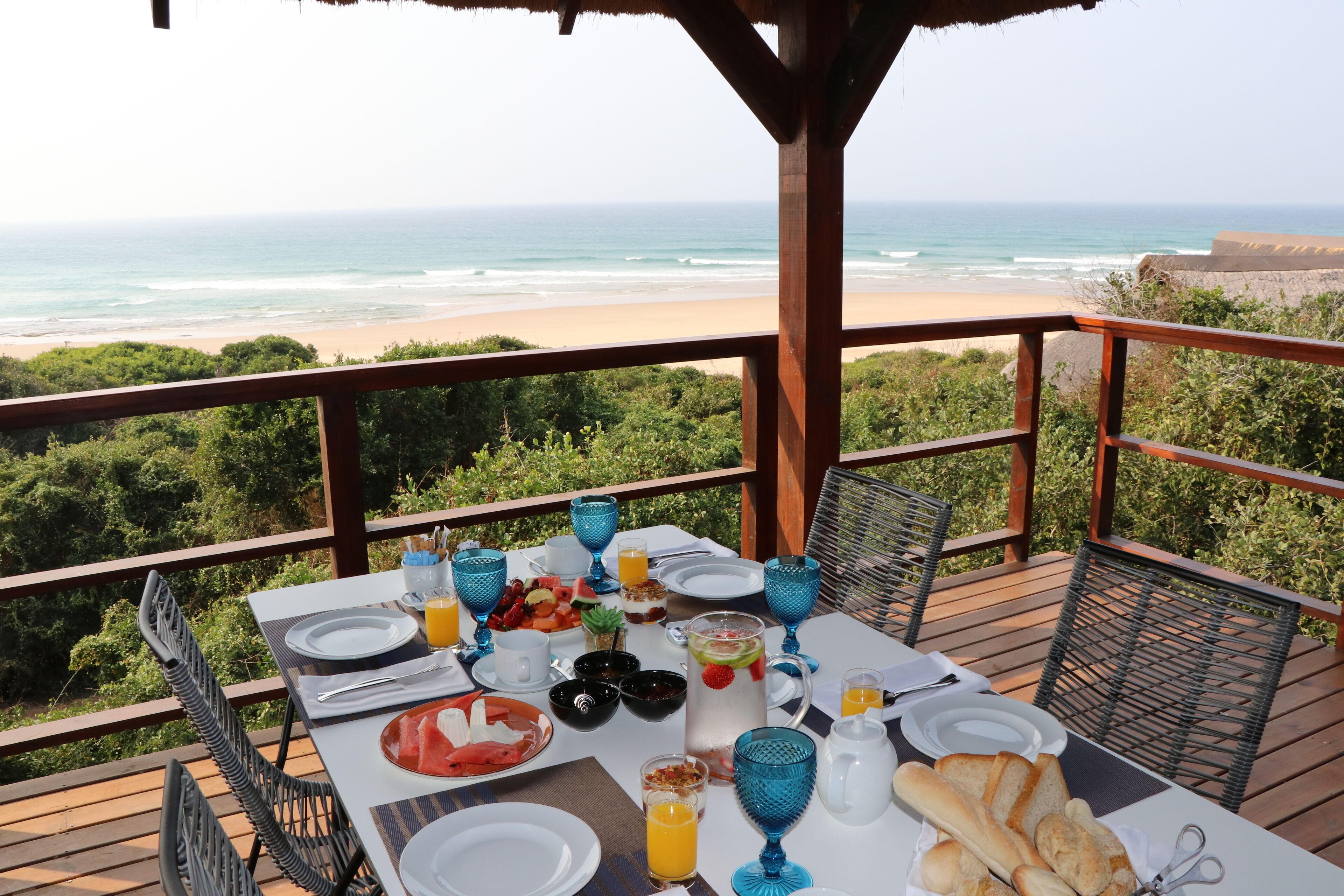 Una mesa de comedor en una terraza con vista al océano.