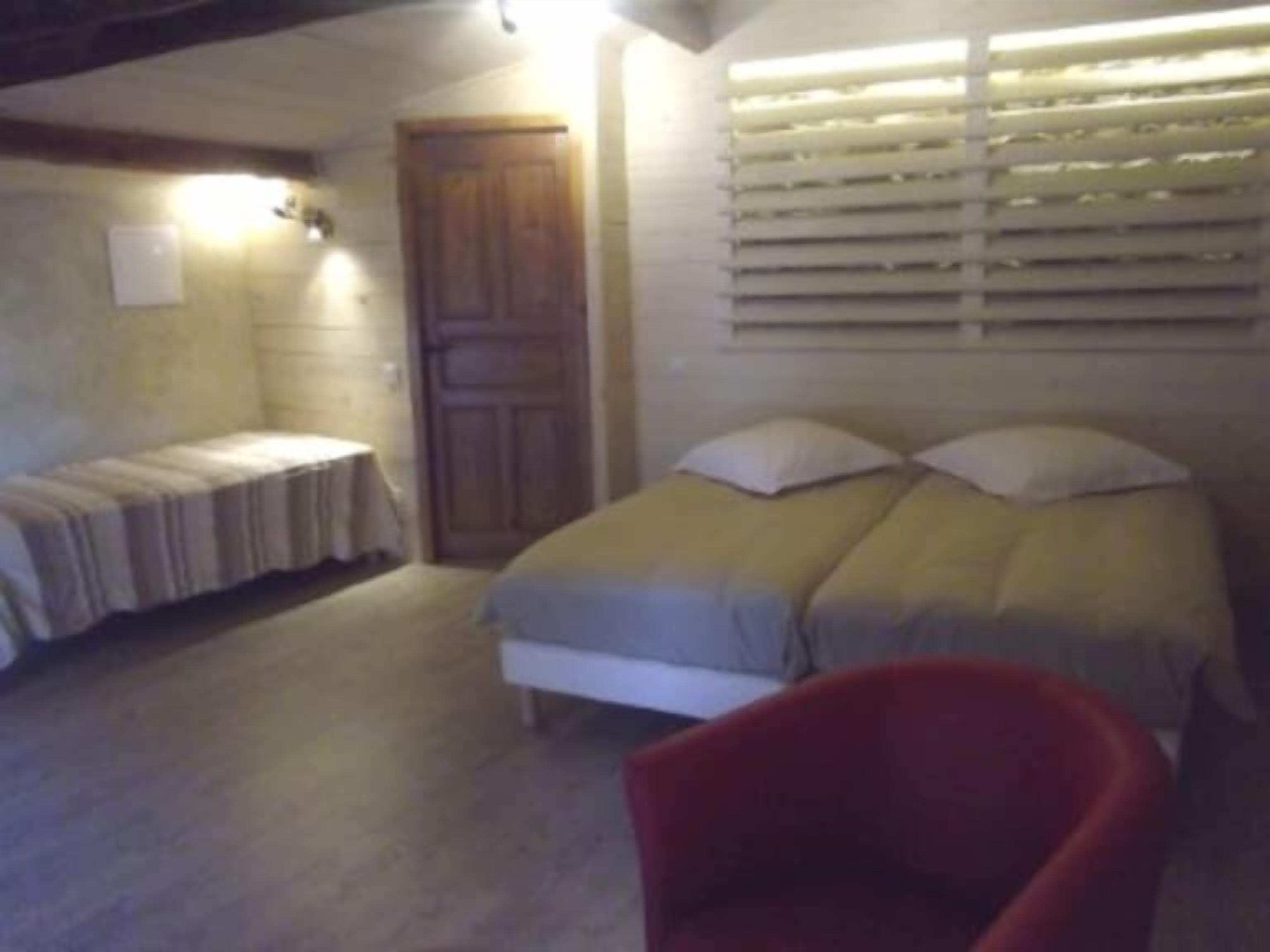 Een slaapkamer met een bed, een stoel en een raam met jaloezieën.
