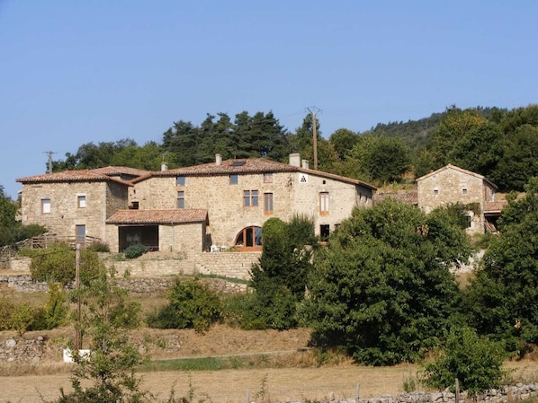 Traditional stone building with a well-planned facade and lush surroundings.