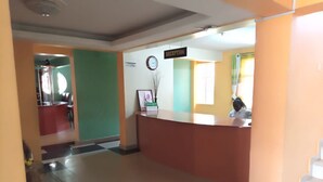 A reception area with a reception desk, a clock, and a sign indicating the reception. - Drimz Hotel Busia (Busia)