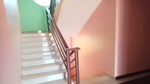 A staircase with a handrail, white steps, and a green wall. - Drimz Hotel Busia (Busia)
