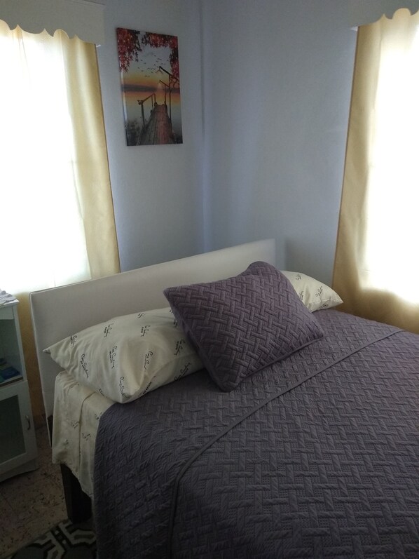 Habitación cuádruple | Cortinas blackout, tabla de planchar con plancha y ropa de cama 