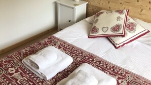 A hotel room with a bed, a nightstand, a lamp, and a poster on the wall. - Spacious 2-bed apartment in Morzine on ski bus route (Morzine)