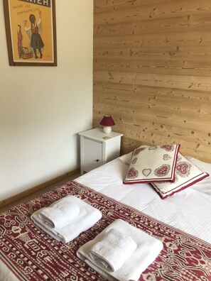 Ein Hotelzimmer mit Bett, Nachttisch, Lampe und einem Bild an der Wand.