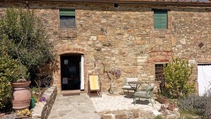 Un edificio in pietra con un cortile, un'apertura e posti a sedere all'aperto.