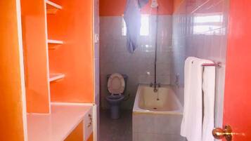 A bathroom with a toilet, bathtub, and a towel rack.