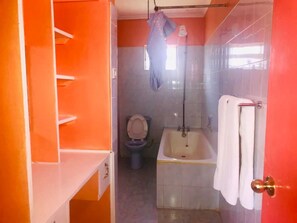 A bathroom with a toilet, bathtub, and a towel rack. - Watercrest Gardens (Eldoret)