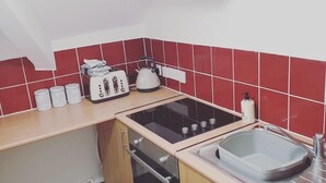 Eine kleine Küche mit einem Gasherd, einem Spülbecken und einem Toaster.