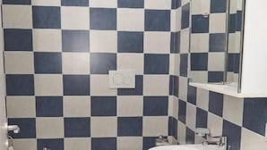 A bathroom with a checkered tile pattern, a bidet, a toilet, a sink, and a mirror. - La Perla Del Sole (Corigliano-Rossano)