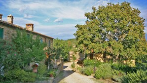 Un bâtiment rustique en pierre, avec un chemin de gravier menant à une porte en bois.