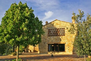 Un bâtiment en pierre doté d’une grande fenêtre et d’un treillis en bois.