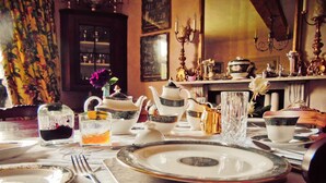 A dining table set with white and gold dinnerware, including plates, bowls, and a teapot. - Yew Tree House (Stourport-on-Severn)