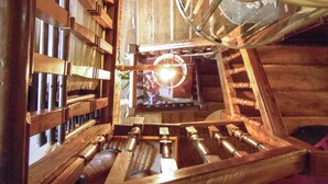 A wooden interior with a spiral staircase, wooden shelves, and a central light fixture. - Yew Tree House (Stourport-on-Severn)
