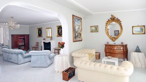 Un salon spacieux avec une cheminée, un grand miroir et un meuble en bois classique.