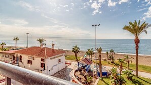 Uitzicht op de kust met een gebouw waarop 'TERRAZA PLAYA' staat en een klein blauw gebouwtje met een bord 'El Castillo'.