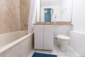 A bathroom with a bathtub, a toilet, and a sink.